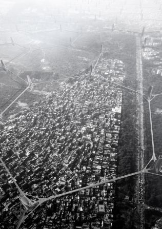 An aerial view of Delhi with a hexagonal grid of filter towers, joined together by proposed "sky bridges" containing solar hydrogen cells -- a power source for the towers.