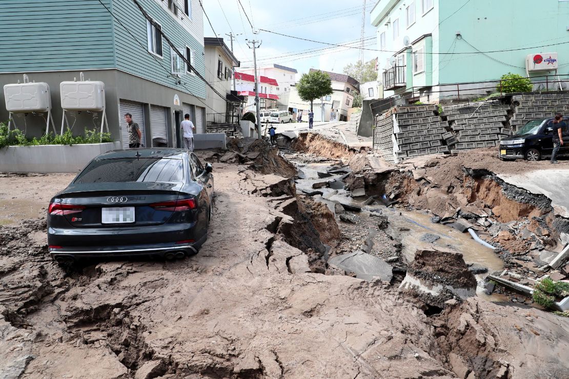 A car is seen stuck on a road damaged by an earthquake in Sapporo, Hokkaido prefecture on September 6, 2018.