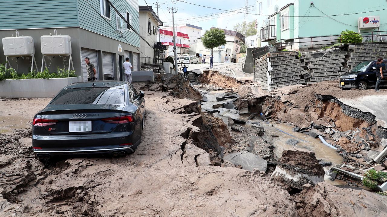 A car is seen stuck on a road damaged by an earthquake in Sapporo, Japan, on September 6, 2018.