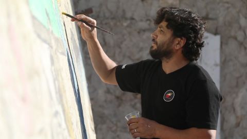 Aziz Al-Asamr works on his mural of Trump.