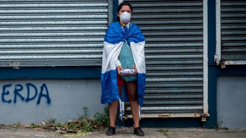 A young woman pauses after spray painting graffiti stencils of the faces of missing and imprisoned students on the street and on walls lining the route for the September 2 protest in Managua.
