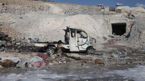 A burned vehicle and personal belongings are seen Saturday in Hass, Syria, after an airstrike.