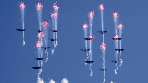 Airplanes forming the number 70 fly in formation and fire flares during the parade.