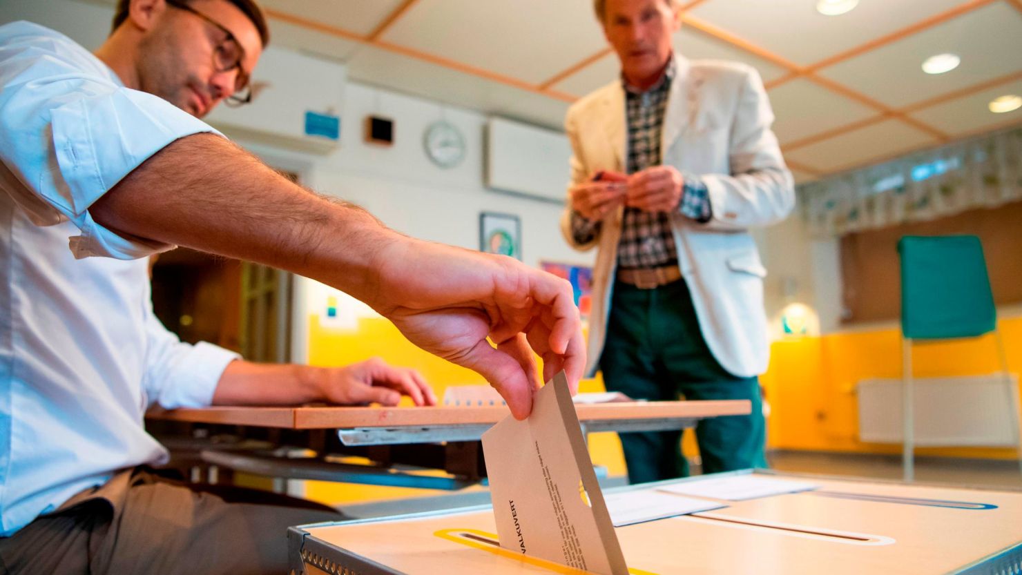 An election official casts a voter's ballot at a polling station in Stockholm on Sunday.