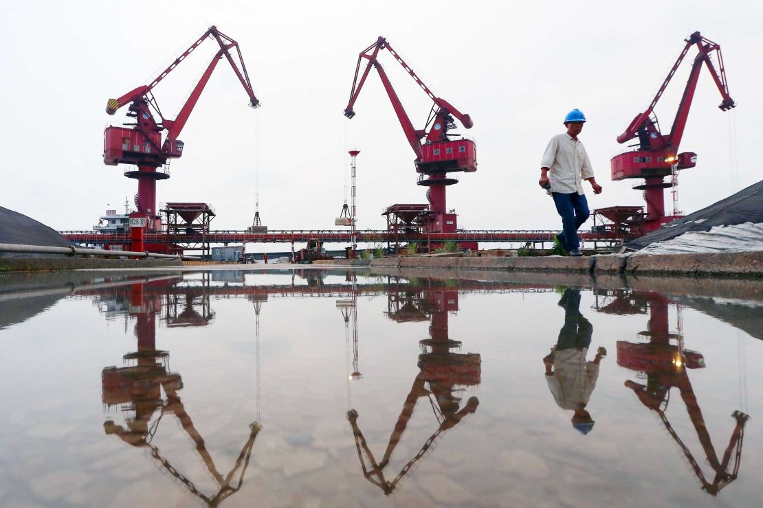 Workers walk as crane buckets transfer soybeans imported from Brazil at a port in Nantong in China's eastern Jiangsu province. 