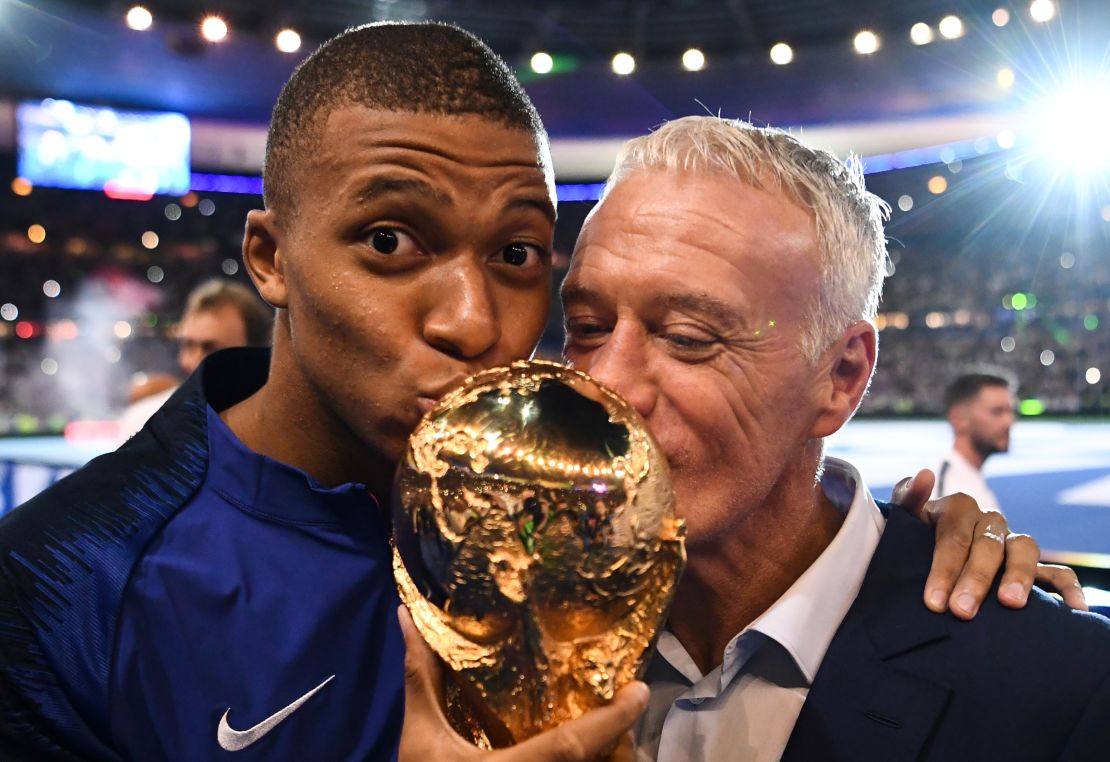 Mbappe and France coach Didier Deschamps kiss the World Cup as they celebrate during a ceremony in Paris after victory over the Netherlands.