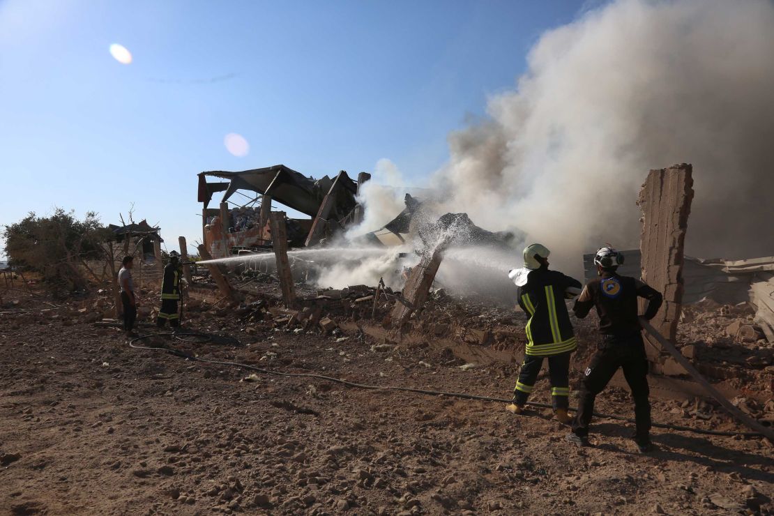 The volunteer White Helmets hose down an airstrike site in Khan Sheikhoun on Friday.