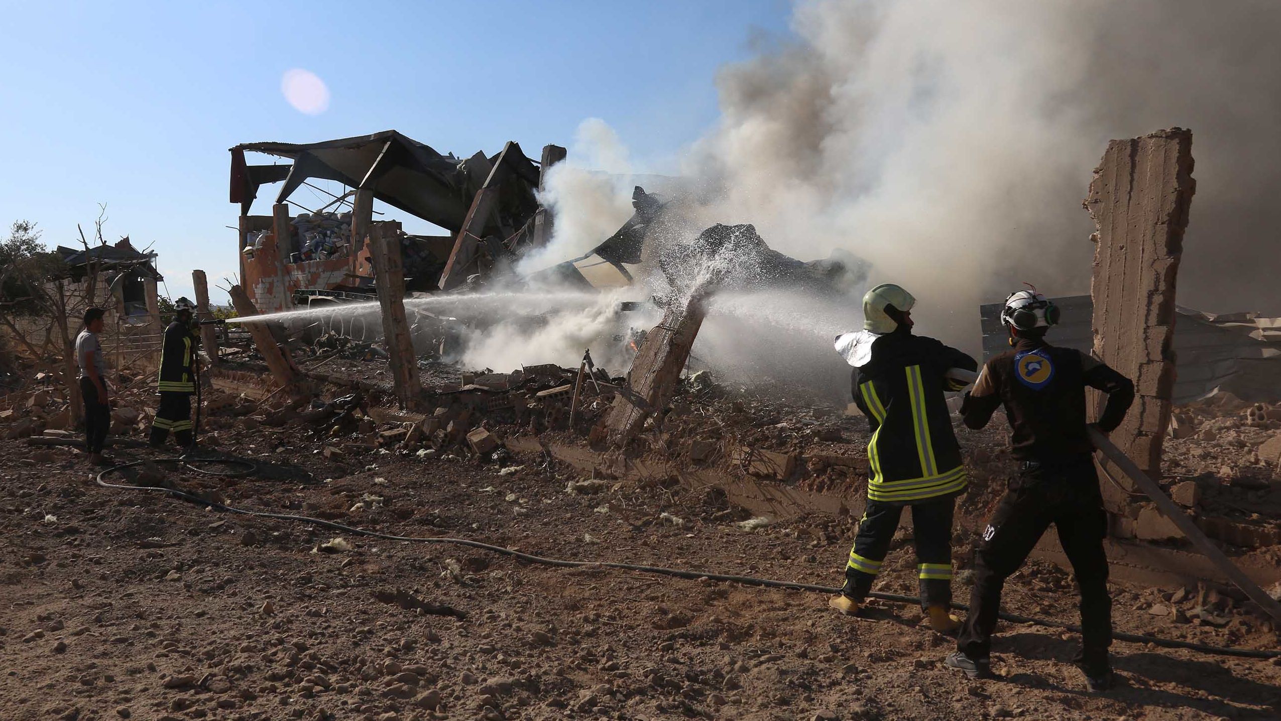 The volunteer White Helmets hose down an airstrike site in Khan Sheikhoun on Friday.