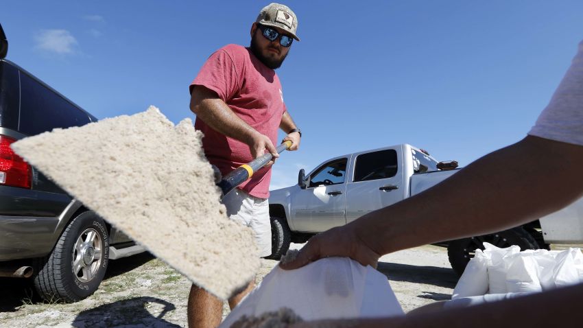 Walker Townsend, at left, from the Isle of Palms, S.C., fills a sand bag while Dalton Trout, at right, holds the bag at the Isle of Palms municipal lot where the city was giving away free sand in preparation for Hurricane Florence at the Isle of Palms S.C., Monday, Sept. 10, 2018. (AP Photo/Mic Smith)