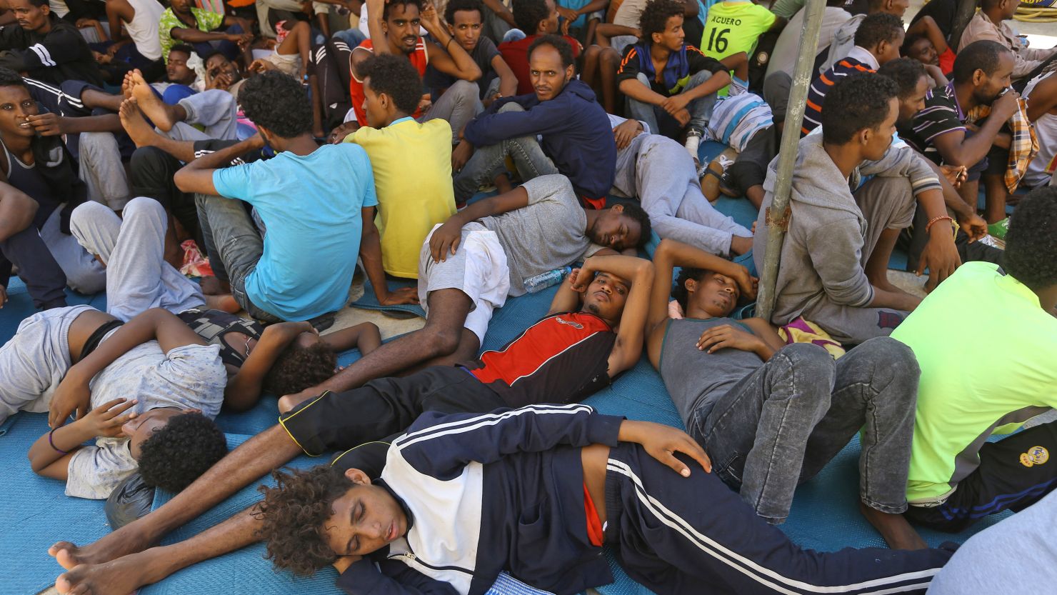 Migrants sit inside a shelter on September 5 after being moved away from clashes in Tripoli.