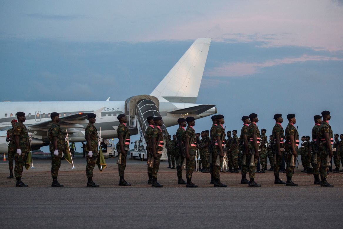 Soldiers from the Ghanaian military stand to attention as the plane carrying the remains of the late diplomat arrived  on the tarmac of Kotoka International Airport. 