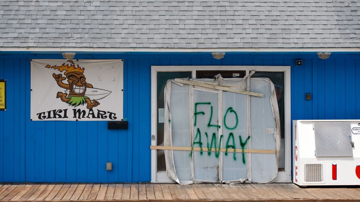 A Tiki bar on Topsail Island, North Carolina sits empty with the message "FLO AWAY" on its door.