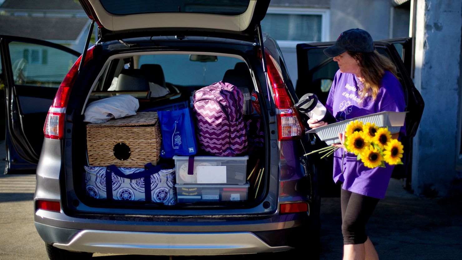 Paula Baker carries flowers she'll leave on her son's grave that she plans on visiting after evacuating her home in Atlantic Beach, North Carolina on Wednesday, as Hurricane Florence approaches the east coast. 