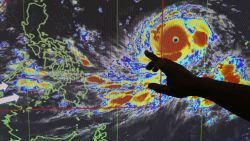 Filipino forecaster Meno Mendoza illustrates the path of Typhoon Mangkhut, locally named "Typhoon Ompong" as it approaches the Philippines with sustained winds of 205 kilometers per hour (127 miles per hour) and gusts of up to 255 kph (158 mph), at the Philippine Atmospheric, Geophysical and Astronomical Services Administration in metropolitan Manila, Philippines on Wednesday, Sept. 12, 2018. Philippine officials say they plan to evacuate thousands of villagers, shut down schools and offices and scramble to harvest rice and corn as the most powerful typhoon so far this year menacingly roars toward the country's north. (AP Photo/Aaron Favila)