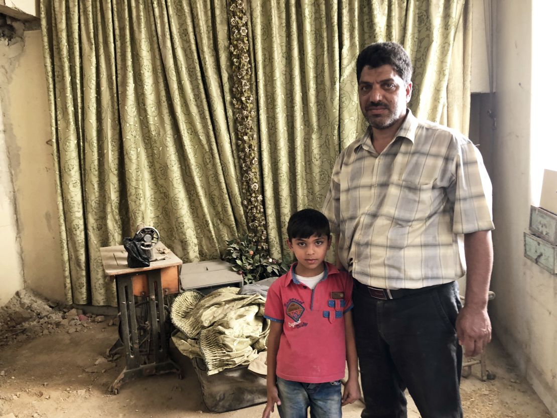 Hussam Ghaboura and his son Mohammad in their living room, which they have been working to restore, six years after the war in Damascus province forced them to flee. 