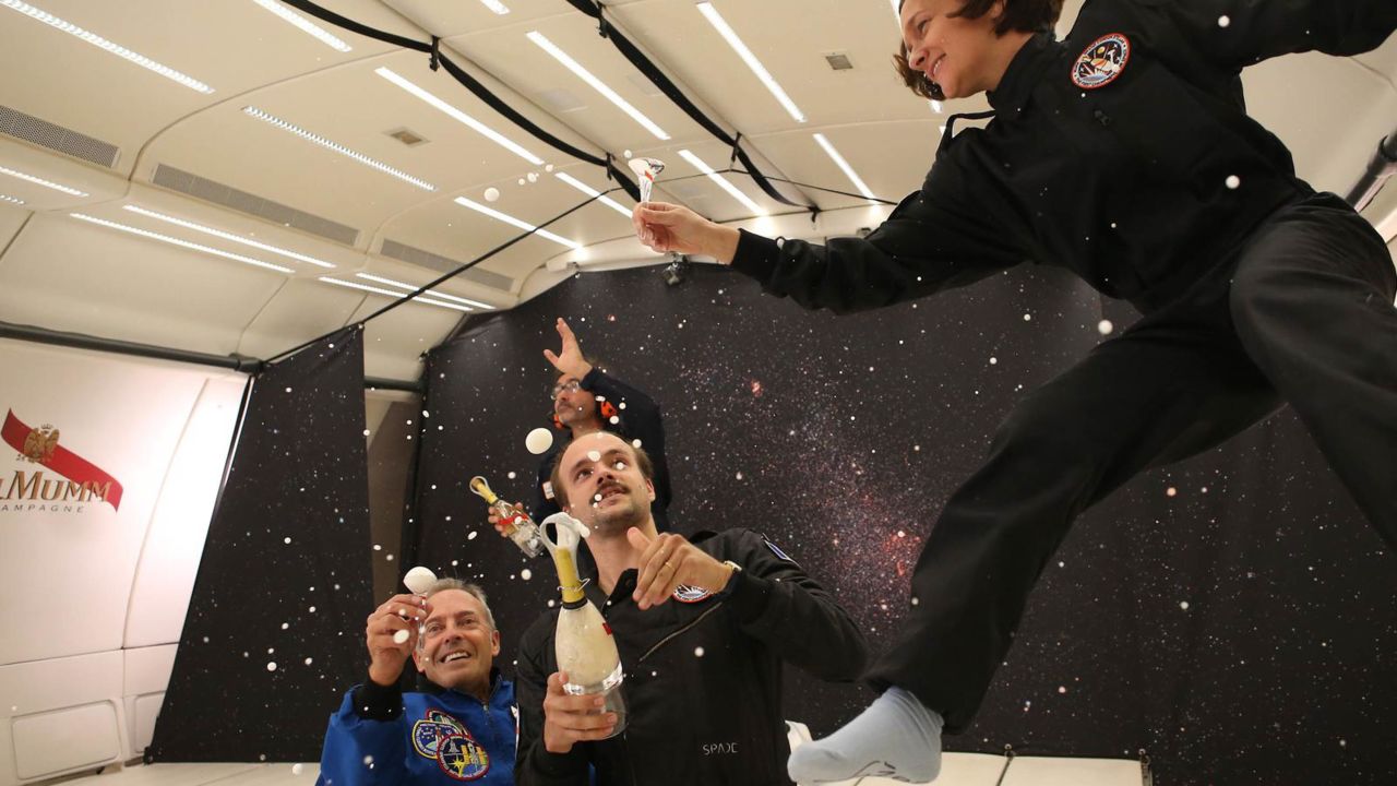 French astronaut Jean-Francois Clervoy, left, tries out the new champagne.