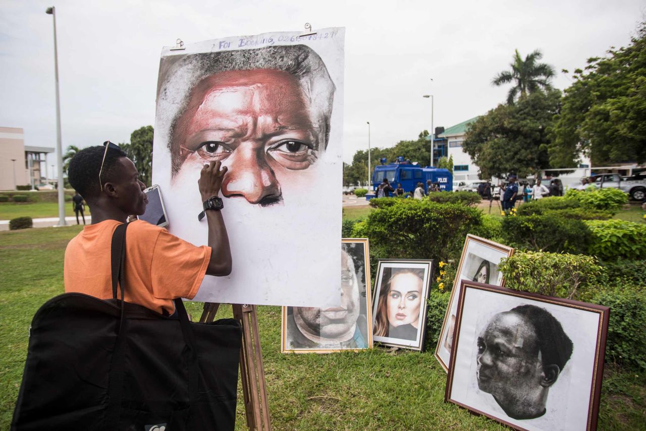 An artist paints a portrait of Annan at the entrance of the conference center on September 11.
