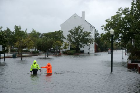 Residents wade through streets flooded by the Neuse River in New Bern on September 13.