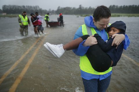 Volunteers help rescue three children from a flooded home in James City, North Carolina, on Friday, September 14. 