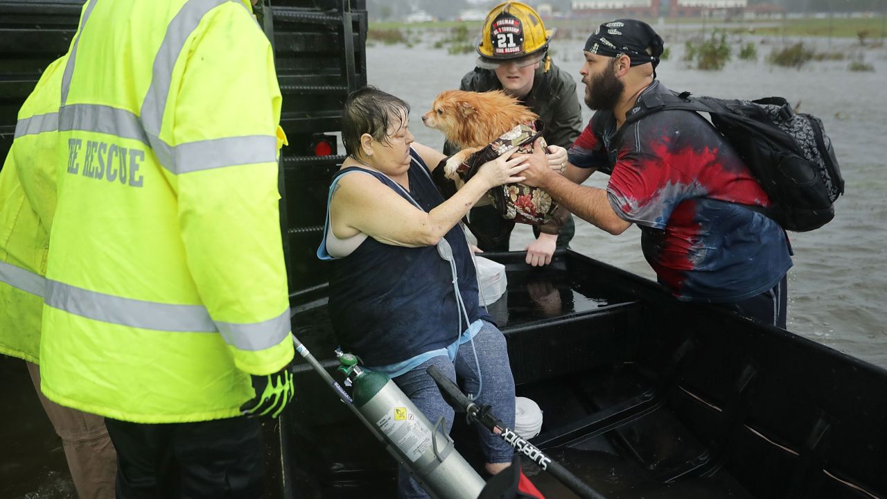 Rescue workers from Township No. 7 Fire Department and volunteers from the Civilian Crisis Response Team help rescue a woman and her dog from their flooded home in James City, North Carolina during Hurricane Florence.