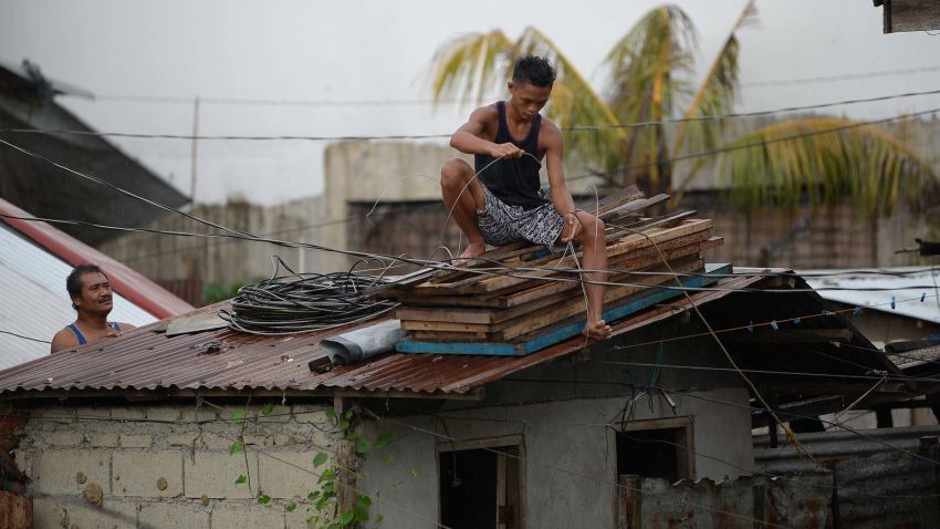 Residents secure the roof of their house as Typhoon Mangkhut approaches the city of Tuguegarao, Cagayan province, north of Manila on September 14, 2018. - Preparations were in high gear in the Philippines on September 14 with Super Typhoon Mangkhut set to make a direct hit in less than 24 hours, packing winds up to 255 kilometres per hour and drenching rains. (Photo by TED ALJIBE / AFP)        (Photo credit should read TED ALJIBE/AFP/Getty Images)