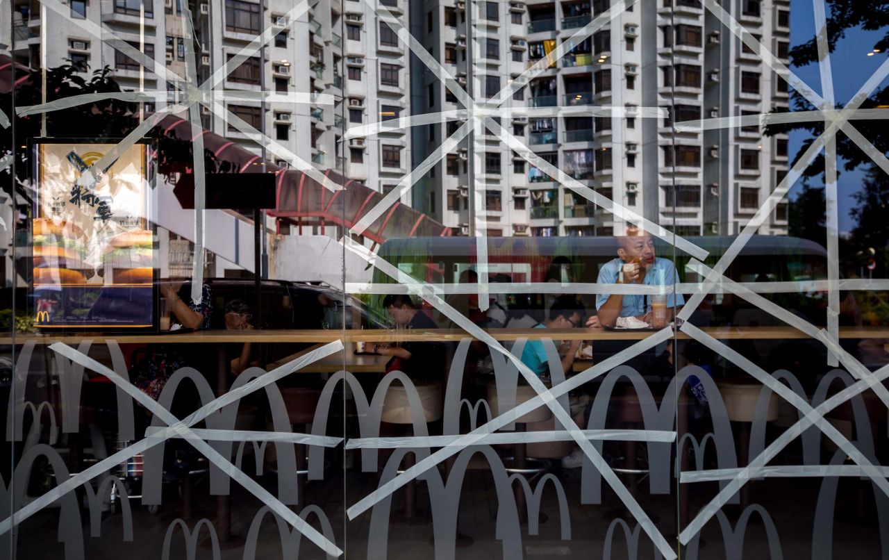 Residential buildings in Hong Kong are reflected in a McDonald's restaurant window, taped in preparation for Typhoon Mangkhut, on September 14. Hong Kong and Macau are currently in the typhoon's path.