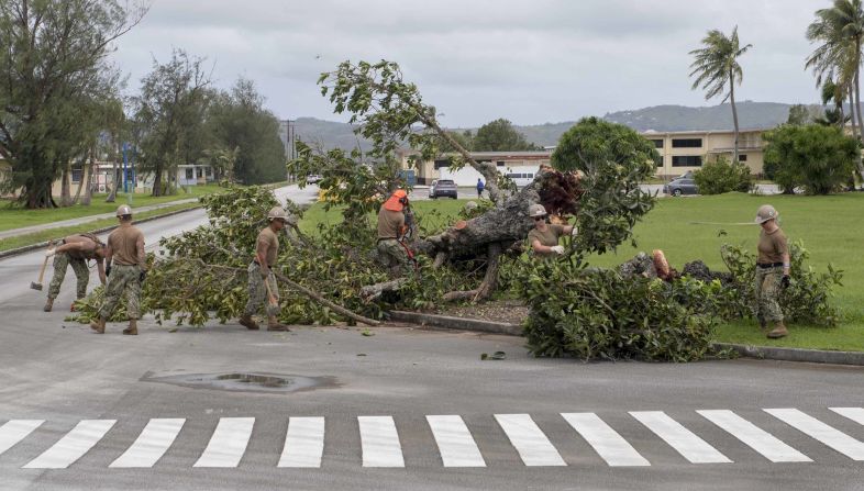 Sailors remove debris on a US naval base in Guam on Tuesday, September 11, after the <a href="index.php?page=&url=http%3A%2F%2Fwww.cnn.com%2F2018%2F09%2F12%2Fasia%2Fsuper-typhoon-mangkhut-ompong-wxc-intl%2Findex.html">typhoon swept through the island territory</a>, causing flooding and power outages.