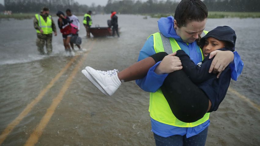 JAMES CITY, NC - SEPTEMBER 14:  Volunteer Amber Hersel from the Civilian Crisis Response Team helps rescue 7-year-old Keiyana Cromartie and her family from their flooded home September 14, 2018 in James City, United States. Hurricane Florence made landfall in North Carolina as a Category 1 storm and flooding from the heavy rain is forcing hundreds of people to call for emergency rescues in the area around New Bern, North Carolina, which sits at the confluence of the Nueces and Trent rivers.  (Photo by Chip Somodevilla/Getty Images)