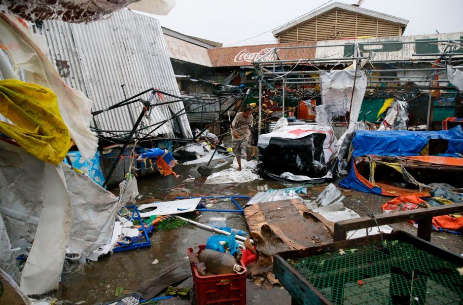 Residents make their way through destroyed stalls at a public market in Tuguegarao City on September 15.