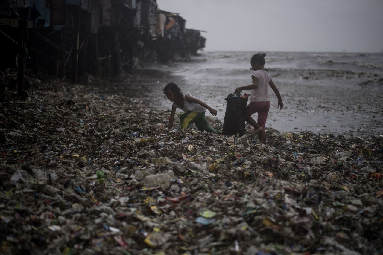 Children collect recyclable materials washed ashore in Manila on September 15.