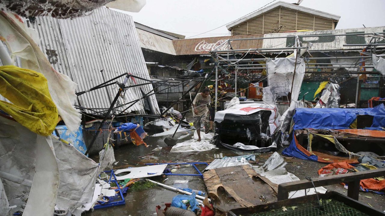 Residents walk along destroyed stalls at a public market due to strong winds as Typhoon Mangkhut barreled across Tuguegrao city in Cagayan province, northeastern Philippines on Saturday, Sept. 15, 2018. The typhoon slammed into the Philippines northeastern coast early Saturday, it's ferocious winds and blinding rain ripping off tin roof sheets and knocking out power, and plowed through the agricultural region at the start of the onslaught. (AP Photo/Aaron Favila)