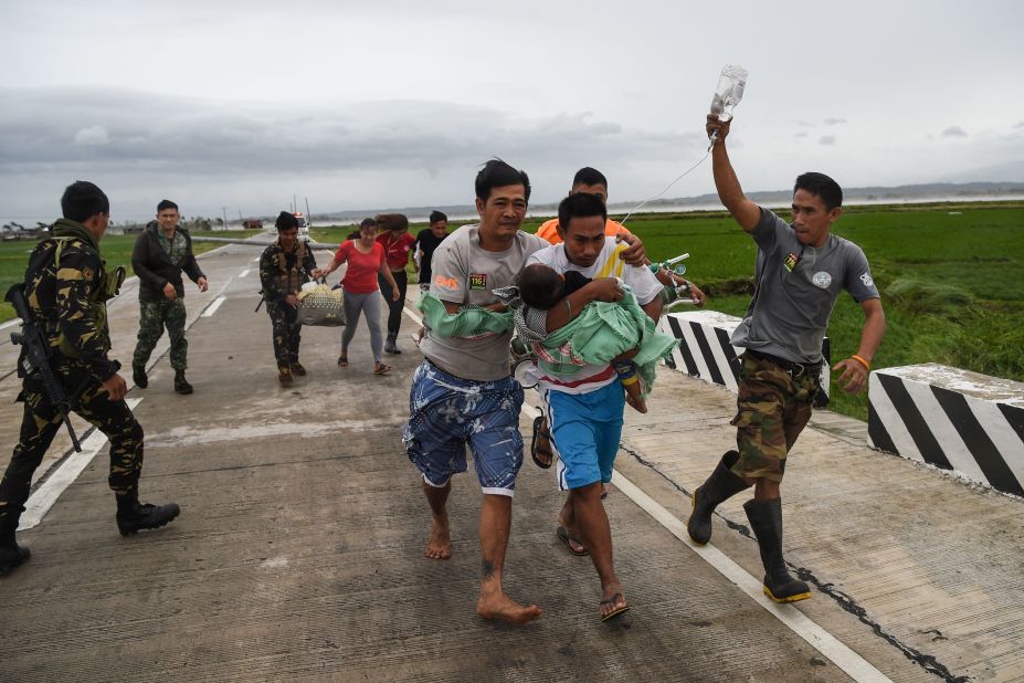 Philippine soldiers help a man with a sick child after fallen electric poles blocked an ambulance transporting them in Baggao, a town north of Manila, on September 15.