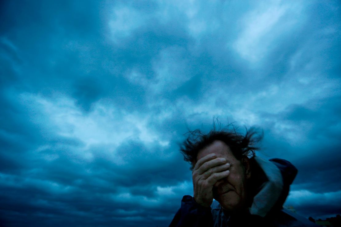 Russ Lewis covers his eyes from a gust of wind and a blast of sand as Hurricane Florence approached Myrtle Beach, South Carolina
