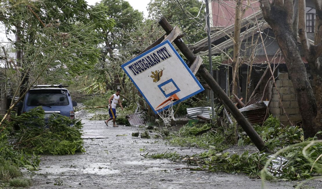 A resident walks beside a toppled basketball court after Typhoon Mangkhut barreled across Tuguegarao city,  Cagayan province.