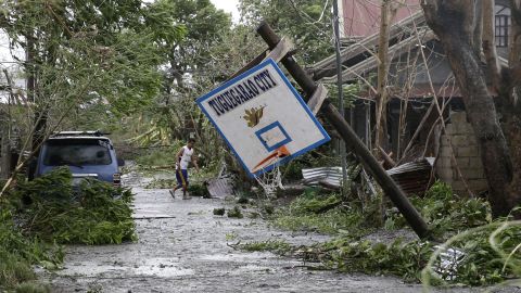 A resident walks beside a toppled basketball court after Typhoon Mangkhut barreled across Tuguegarao city,  Cagayan province.