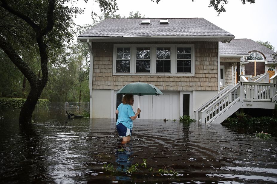 Kim Adams wades through floodwaters surrounding her home in Southport, North Carolina, on September 15.