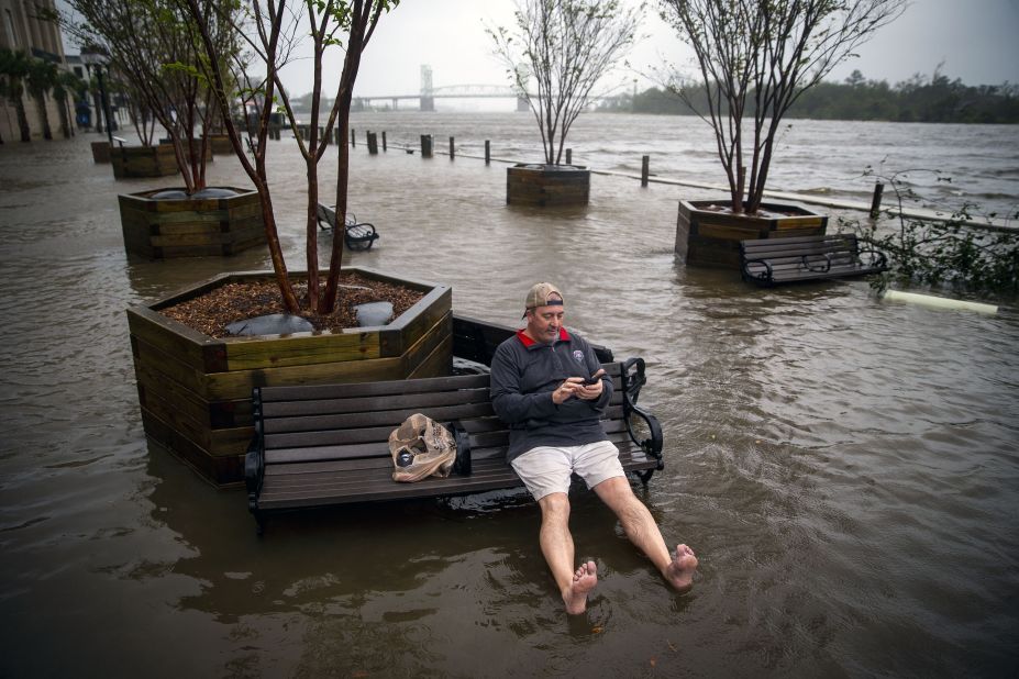 Ray Baca of Wilmington, North Carolina, checks his phone as he sits on a bench.