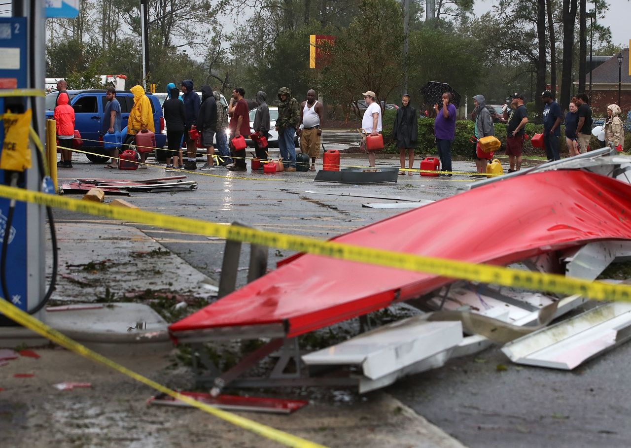 People wait in line to fill gas cans at a gas station that was damaged when Florence hit Wilmington, North Carolina, on Saturday.