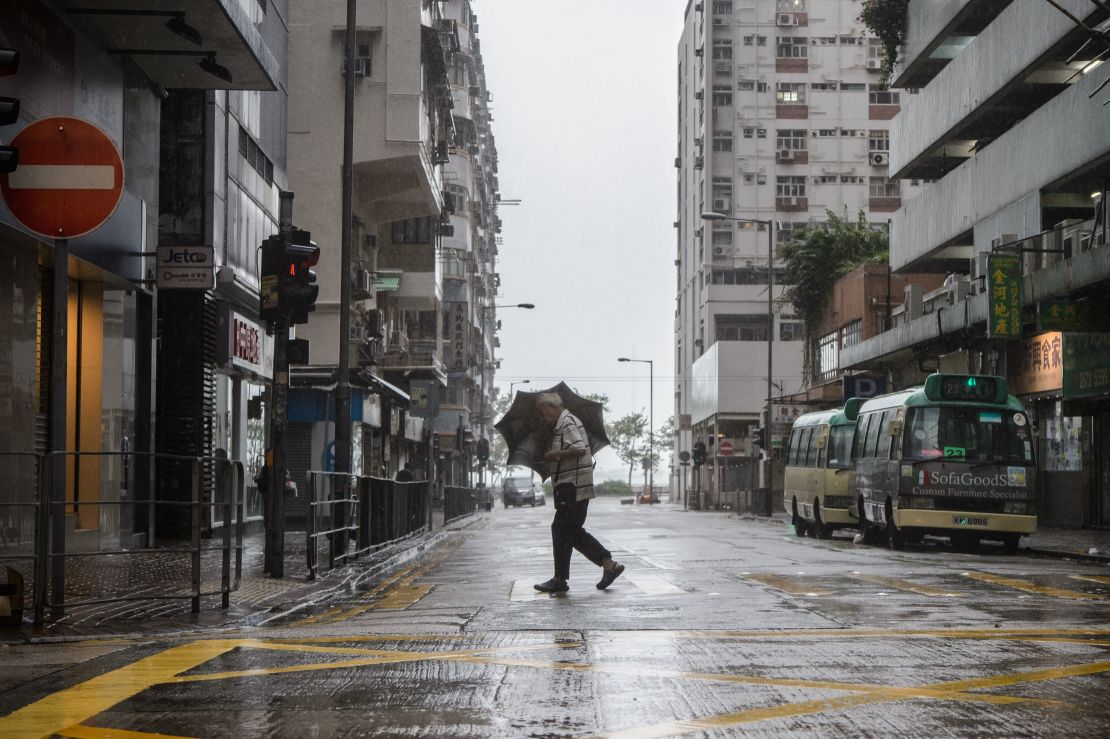 A man uses his umbrella while crossing a road as super Typhoon Mangkhut edges closer to Hong Kong on September 16, 2018.