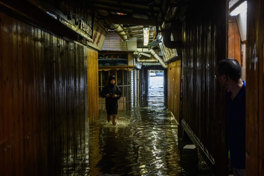 Villagers look down an alleyway filled with seawater in Lei Yu Mun on Sunday.
