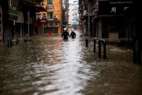 Rescue workers wade through floodwaters during a rescue operation in Macau on September 16.