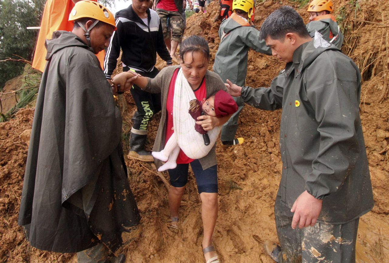 Rescuers assist a mother and her child after the deadly landslide in the Philippines.