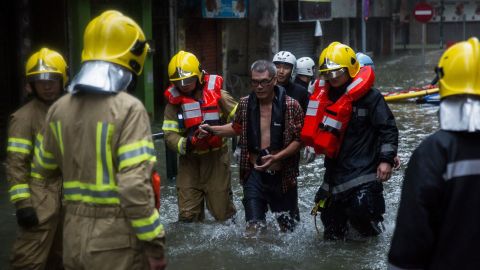 A shop owner is rescued by members of the fire brigade from a flooded area of Macau on Sunday.