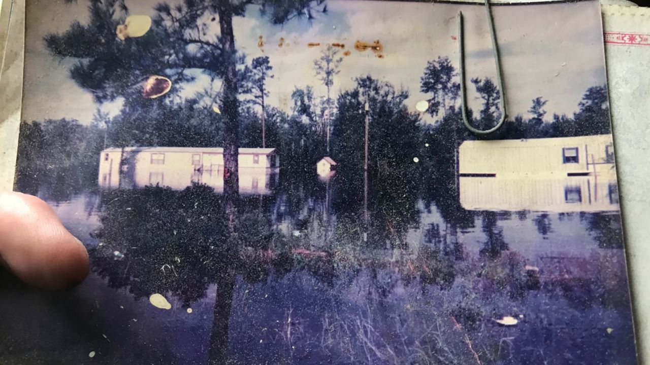 Susan Bostic shows a photo of flooding at her Rocky Point, North Carolina, home during Hurricane Floyd in 1999.