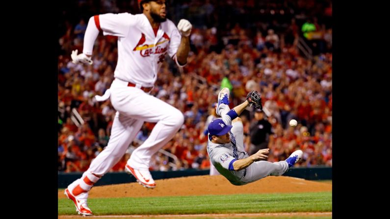 Los Angeles Dodgers third baseman David Freese, right, throws the ball to first base, but St. Louis Cardinals' José Martínez, left, is safe on an error during the fifth inning of the game in St. Louis, on Thursday, September 13.