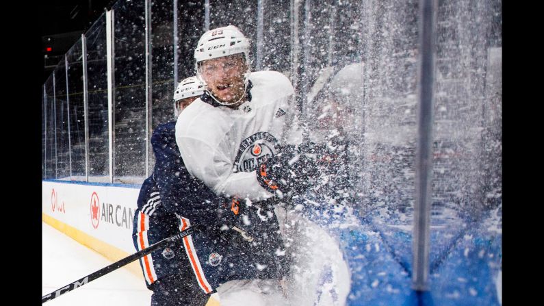 Edmonton Oilers Matthew Benning is checked by Tobias Rieder during NHL hockey training camp in Edmonton, Alberta, on Friday, September 14.