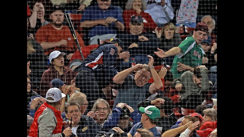 Toronto Blue Jays second baseman Devon Travis' bat goes flying into the stands, hitting a fan, center, in the head during the eighth inning of the game against the Boston Red Sox at Fenway Park on Wednesday, September 12.