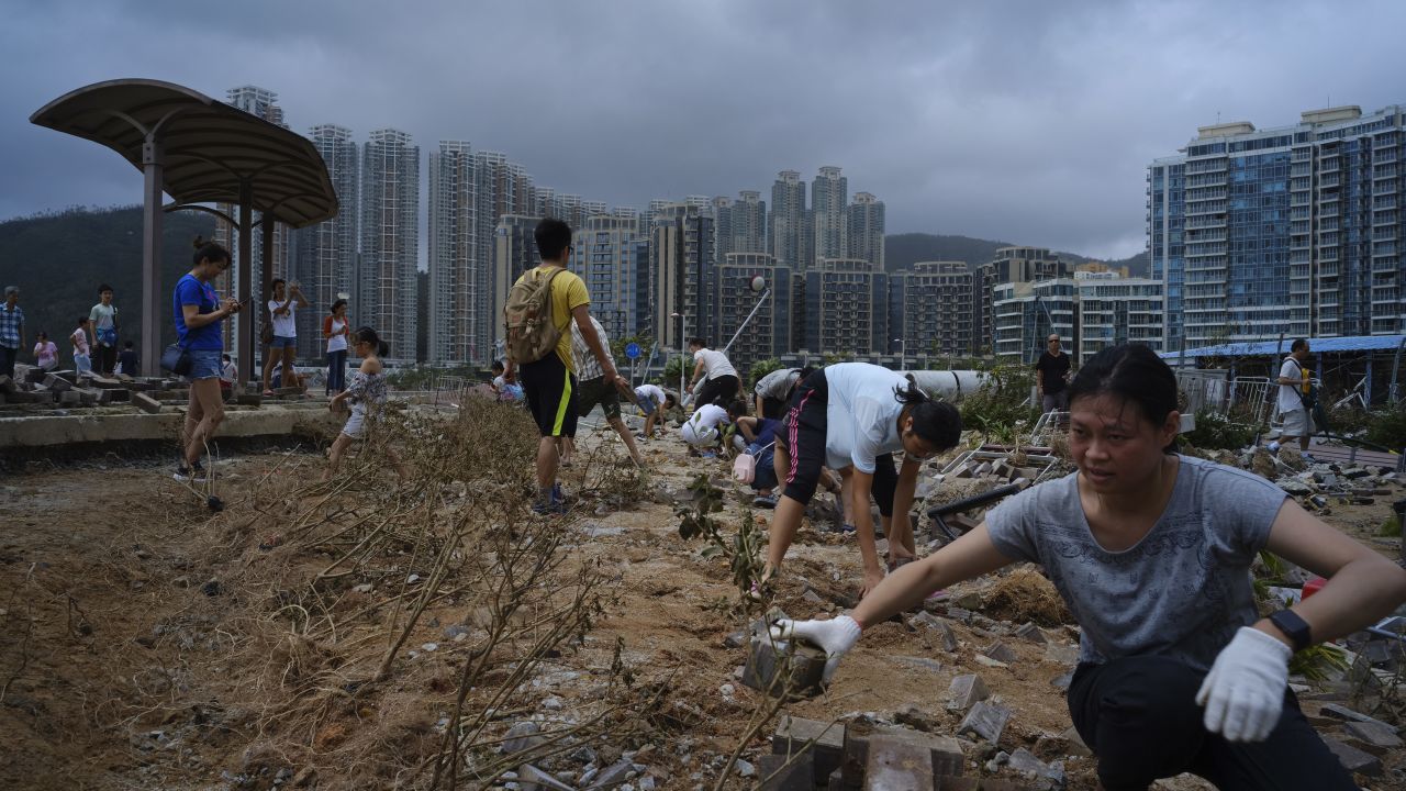 People clean debris from Typhoon Mangkhut on the waterfront in Hong Kong, Monday, Sept. 17, 2018. Hong Kong and southern China hunkered down as strong winds and heavy rain from Typhoon Mangkhut lash the densely populated coast. The biggest storm of the year left at least 28 dead from landslides and drownings as it sliced through the northern Philippines. 