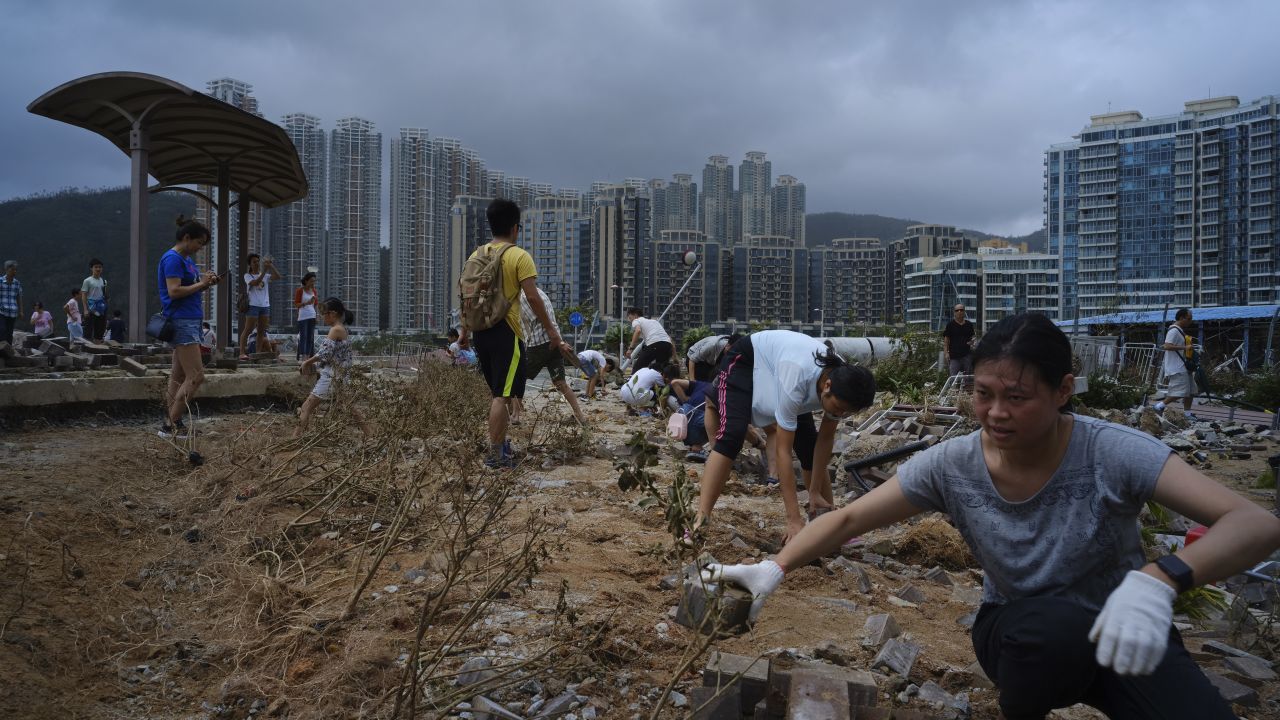People clean debris from Typhoon Mangkhut on the waterfront in Hong Kong, Monday, Sept. 17, 2018. Hong Kong and southern China hunkered down as strong winds and heavy rain from Typhoon Mangkhut lash the densely populated coast. The biggest storm of the year left at least 28 dead from landslides and drownings as it sliced through the northern Philippines.