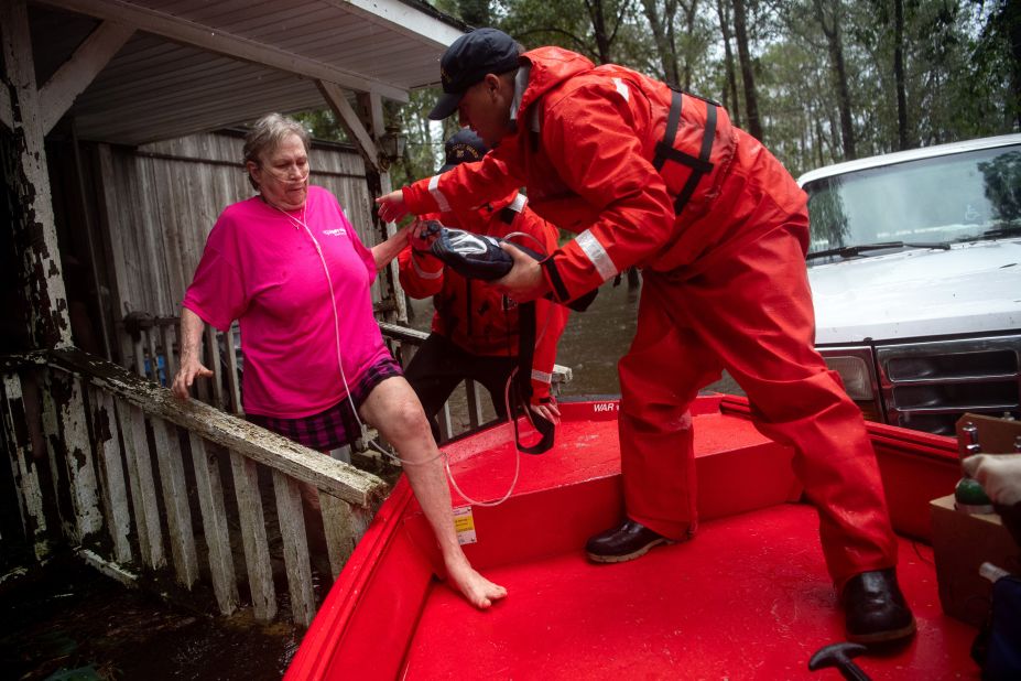 Coast Guard member Blake Gwinn helps Josephine Horne escape her flooded home in Columbus County, North Carolina, on September 16.